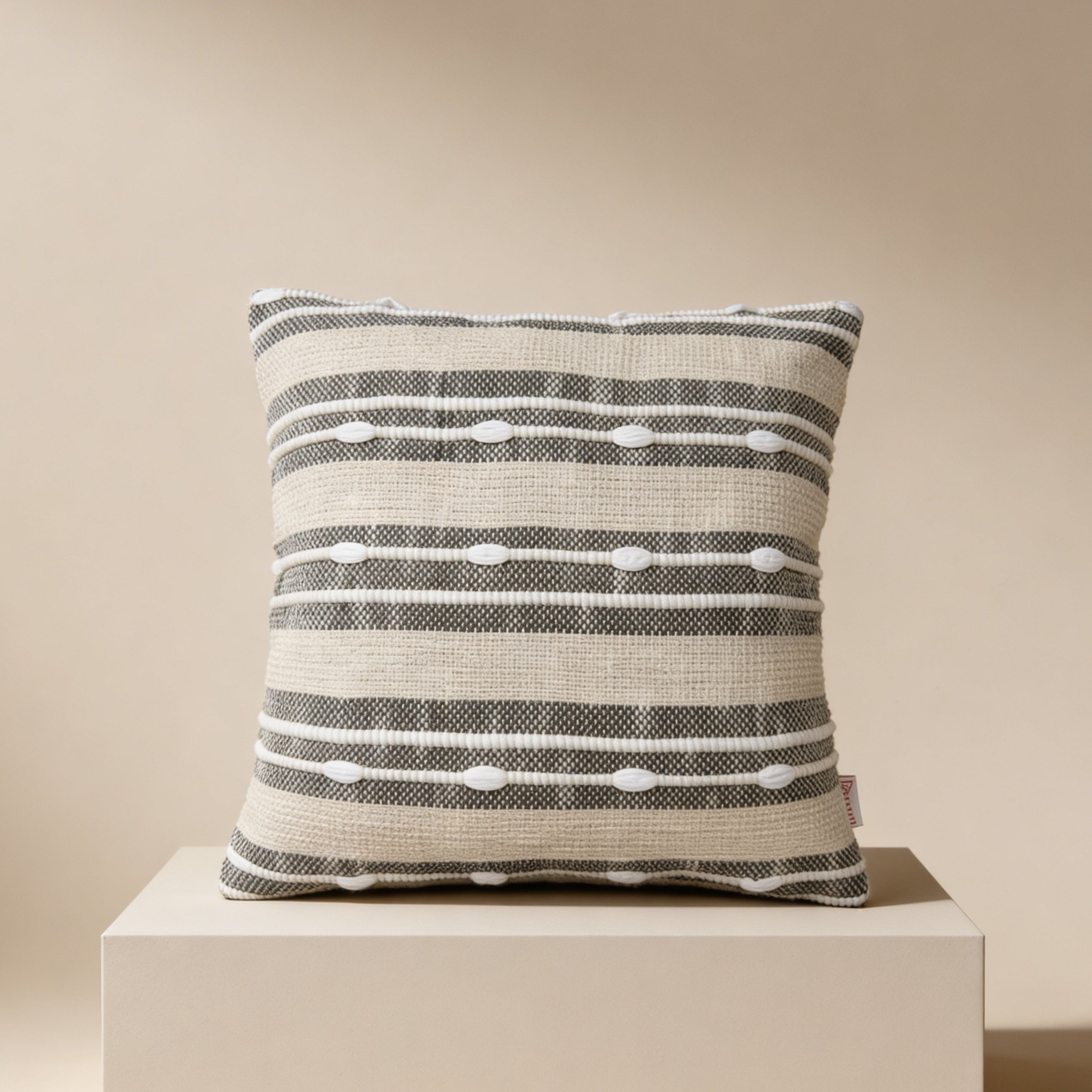 Striped pillow on a beige pedestal against a beige background
